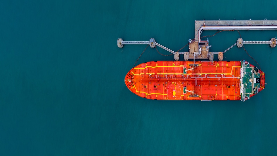 Aerial view red cargo tanker ship vessel at port with marine loading arms, Global business oversea commercial trade logistic import export oil and gas petrochemical from refinery industry transport worldwide.