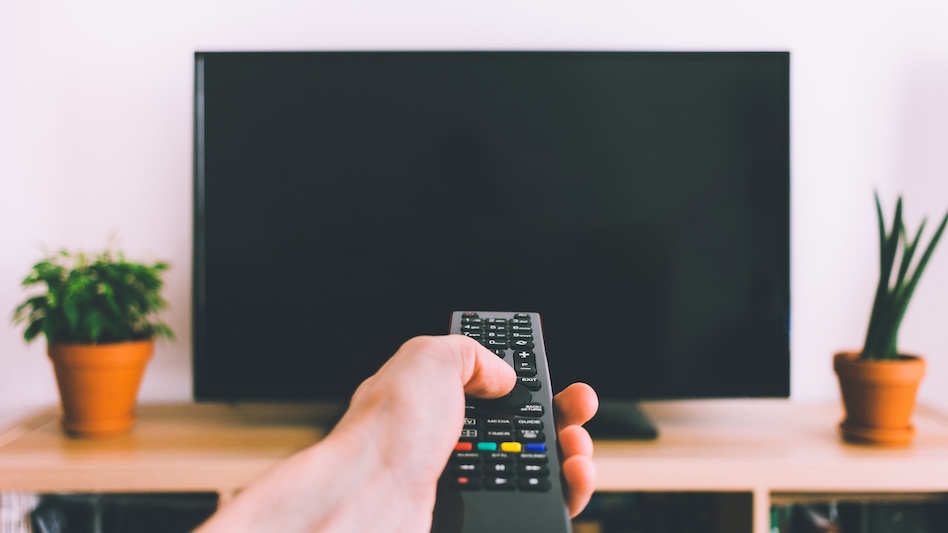 Television with remote control in hand mockup
